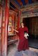 China: A young Tibetan Buddhist monk spins a large prayer wheel, Labrang Monastery, Xiahe, Gansu province